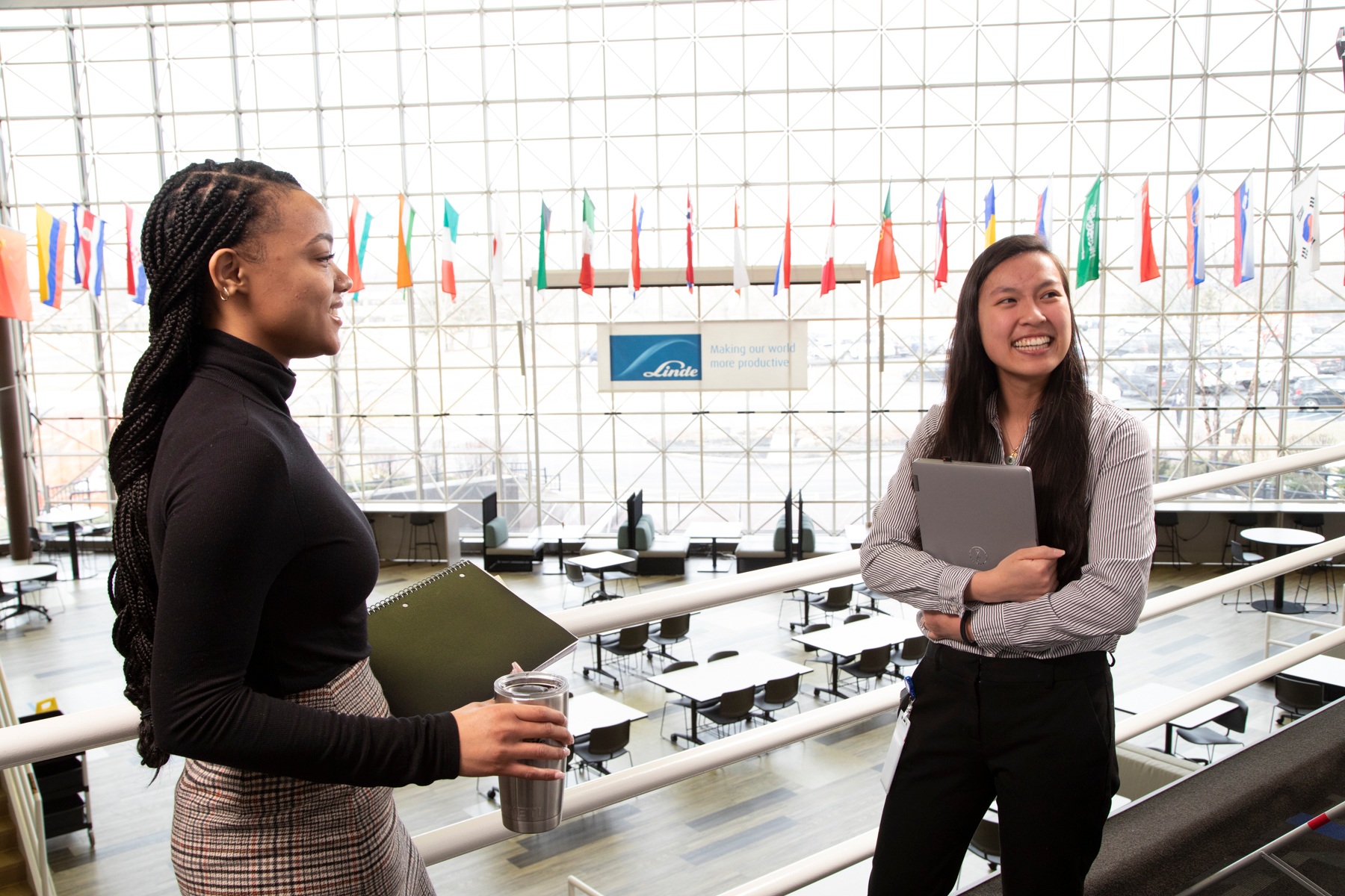 "Two female employees smiling in conversation."