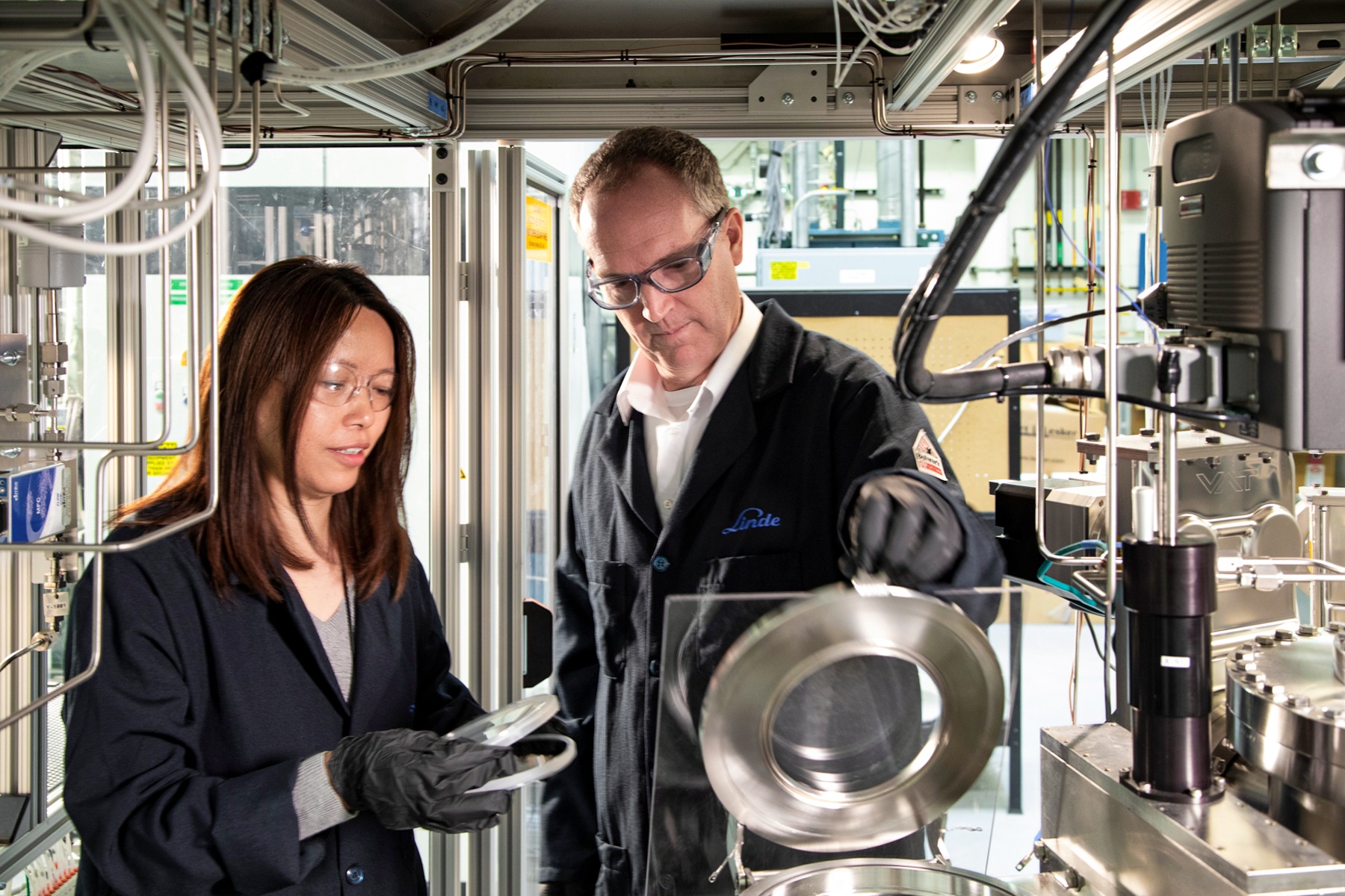 "One male and one female Linde employee working on machinery in an industrial plant"