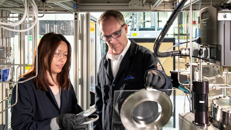 "One male and one female Linde employee working on machinery in an industrial plant"