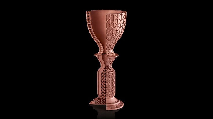 A 3D printed copper rocket part against a black background.