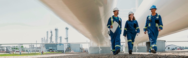 Engineers in workwear walking through industrial plant