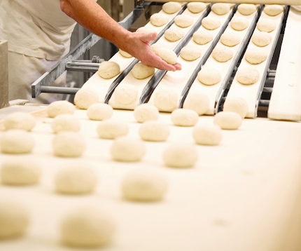 Raw dough balls entering a freezer