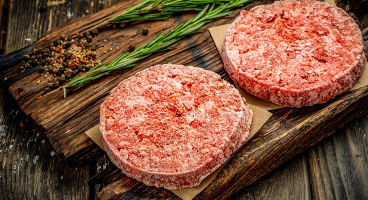 4 nicely arranged raw chicken legs lying next to each other