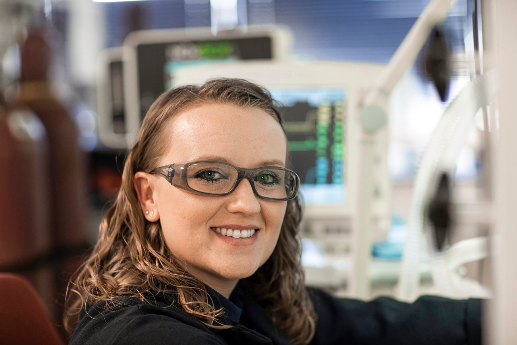 "Close-up of female employee at work sitting in front of medical gas equipment. Linde logo visible on the side."