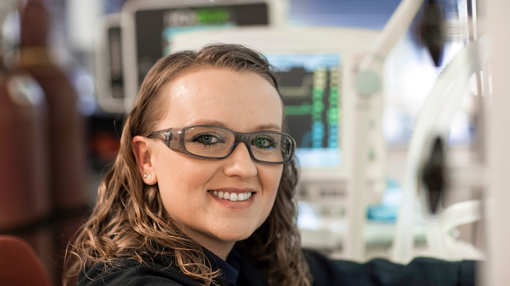 "Close-up of female employee at work sitting in front of medical gas equipment. Linde logo visible on the side."