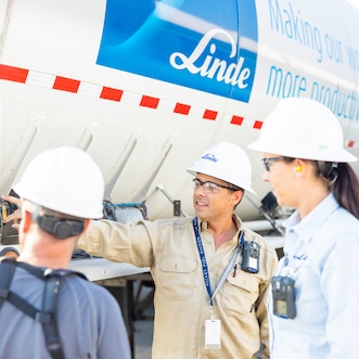 Female engineer and colleagues checking hydrogen truck