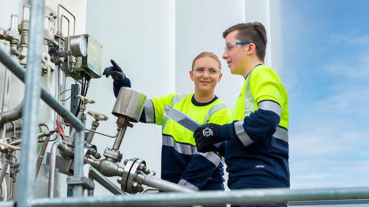 Zwei Auszubildende vor Metallrohren