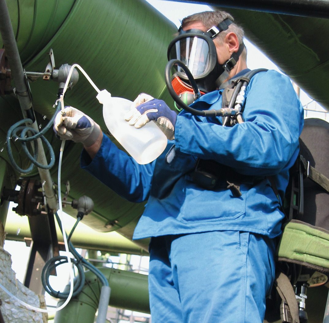 A worker taking a sample for testing at a Claus plant