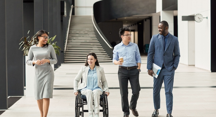 Diverse group of business people chatting in office lobby