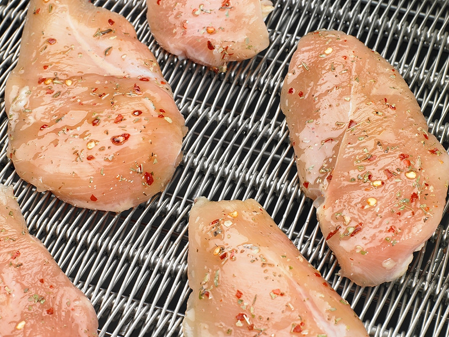 marinated chicken breast entering a freezer