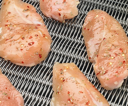 marinated chicken breast entering a freezer