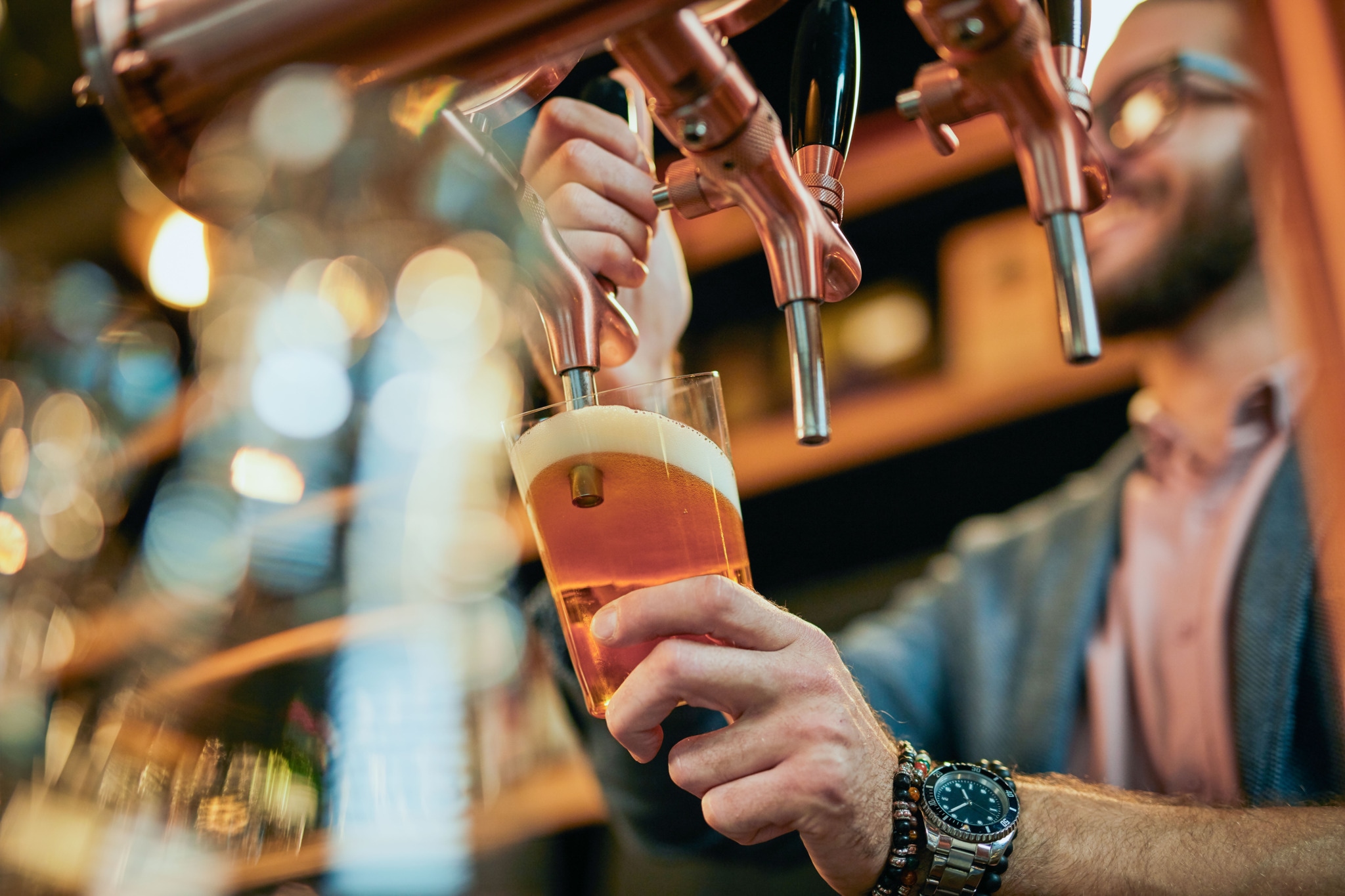 Bartender pouring draft beer from tap